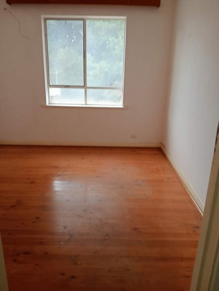 The same room empty and clean with polished timber floors after clearing