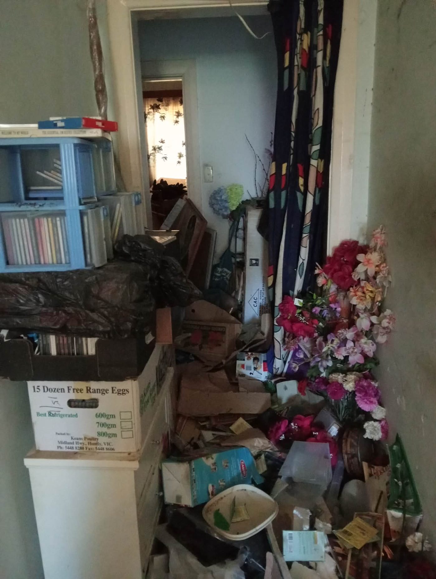 A hallway in a home affected by hoarding, piled high with belongings