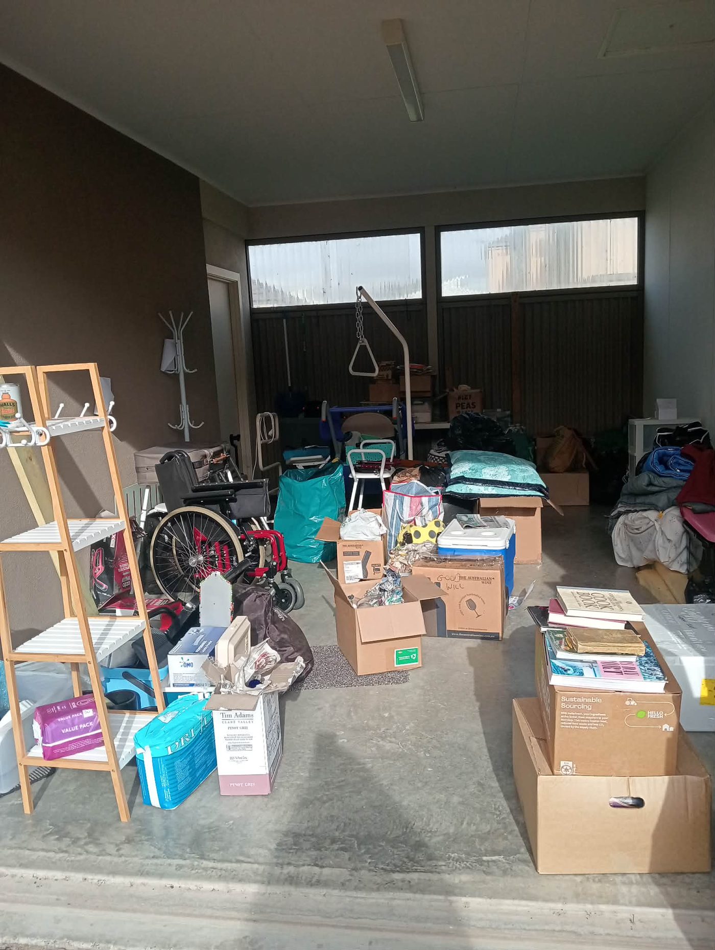 A garage mid-clearance, with belongings sorted into labelled boxes ready for sale, donation or disposal